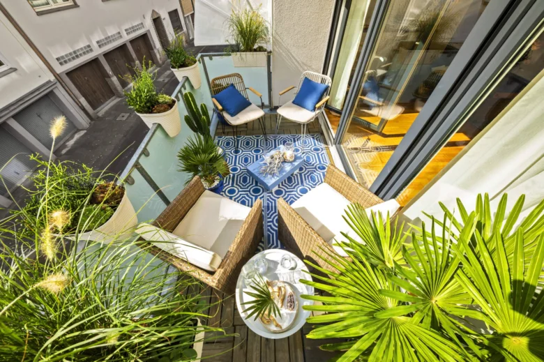 Balkon s mnoha rostlinami v květináčích.
