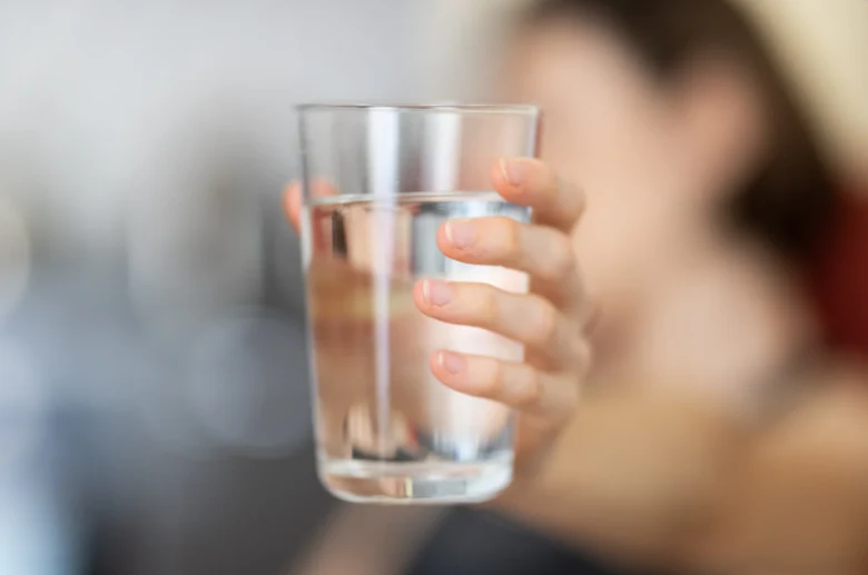 Hand holding glass of water