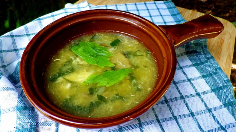 Květáková polévka s vejcem na modro-bílém ubrusu.