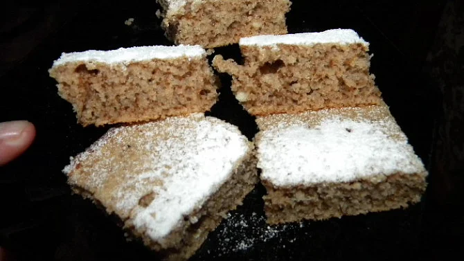Čtyři kousky koláče posypané cukrem pudrem.