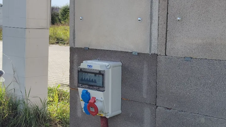 Bílá elektroměrná skříň na zdi pro přívod do stavby.