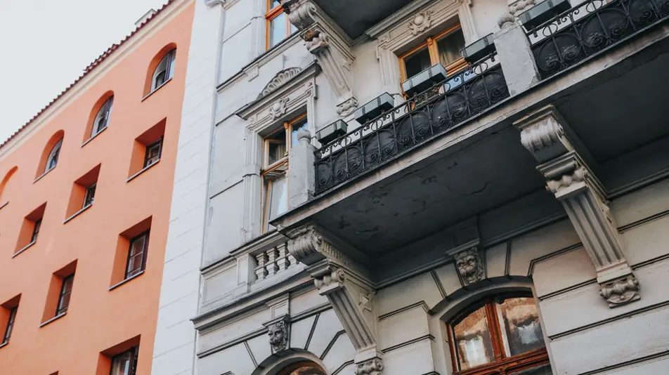 Fasáda historického bytového domu s balkony.