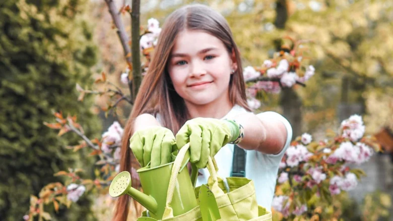 Dívka s zahradnickými nástroji v ruce.