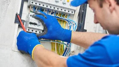 Elektrikář opravuje rozvaděč při stavbě domu Antoníček.