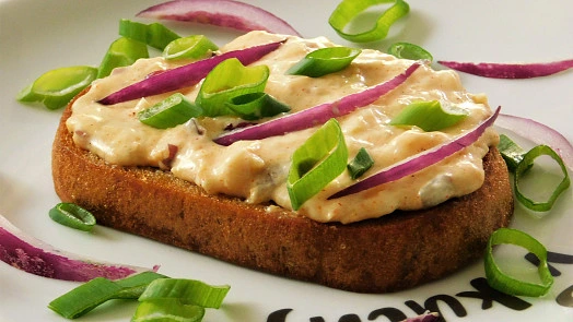 Ovocný toast s zeleninovou směsí na bílém talíři.