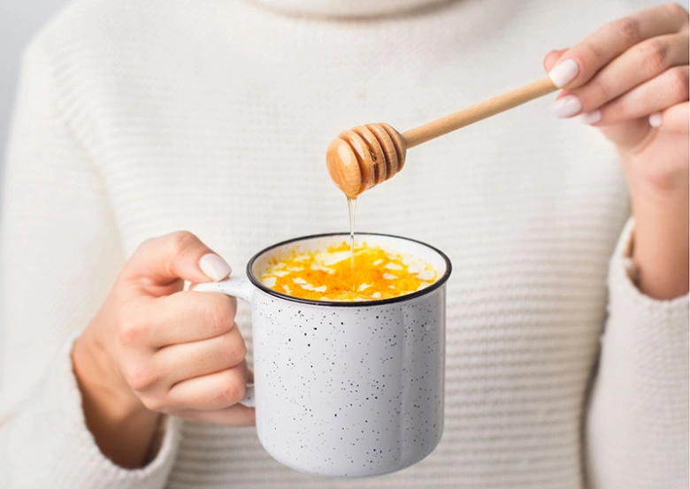 Přidávání medu do šálku s citrusy pro ayurvédskou stravu