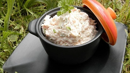 Hotová rizoto s tofu v černé misce na trávníku.