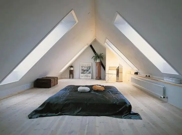 Modern půdní pokoj s velkými okny a dřevěnou podlahou
