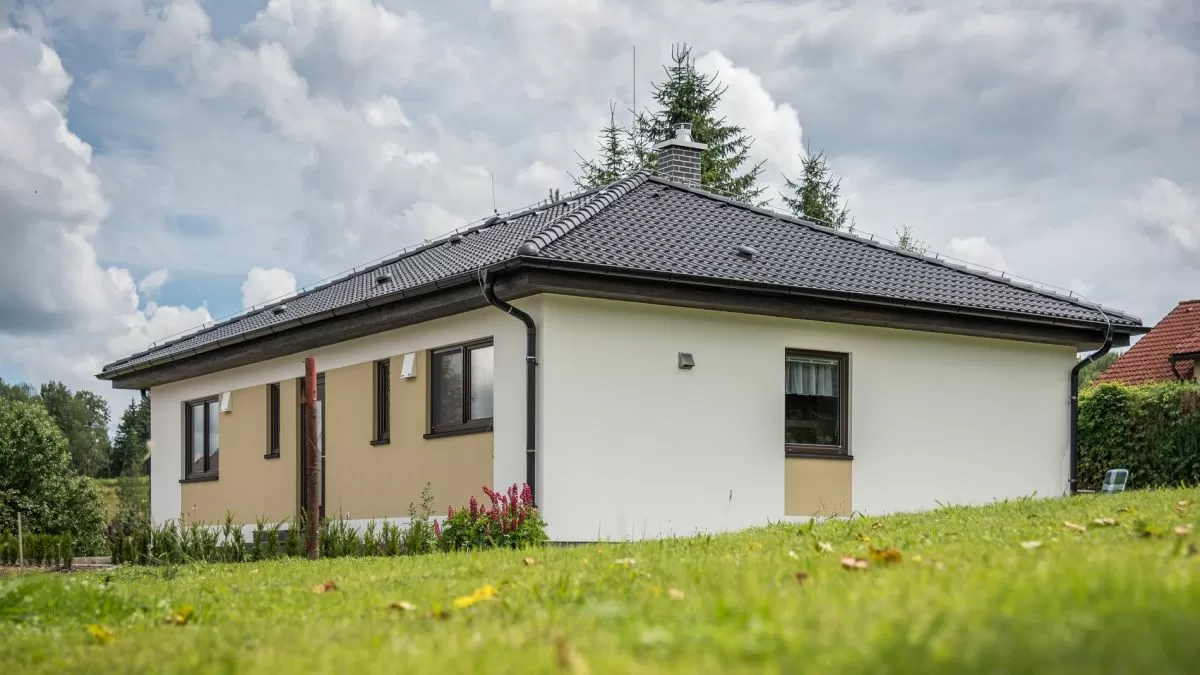 Modern dům typu 4+kk s bílou fasádou na trávníku.