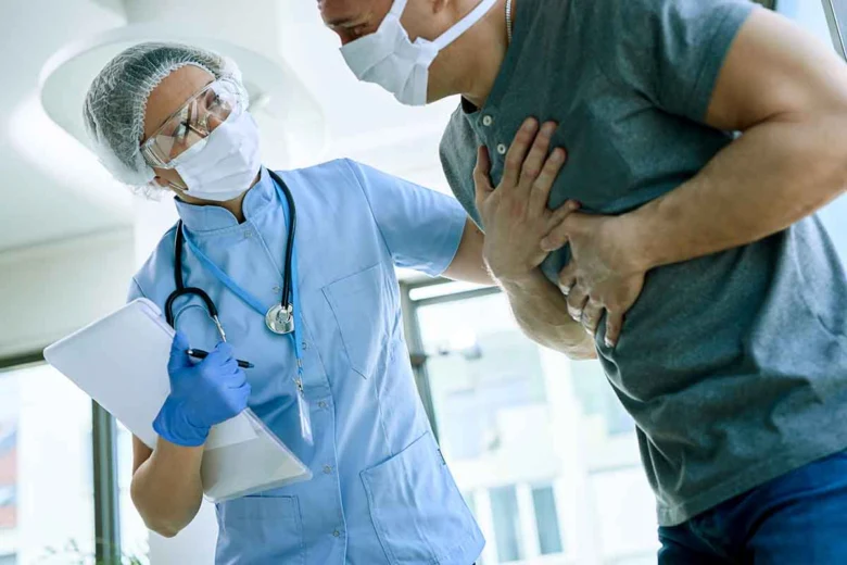 Lékař zkoumá muže s bolestí na hrudi při podezření na tichý infarkt