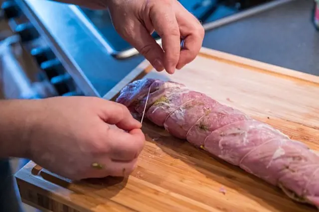 Rozpínání vepřového roláku na dřevěné desce