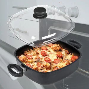 Černý hrnec na indukci s pizzou pod skleněnou pokličkou.