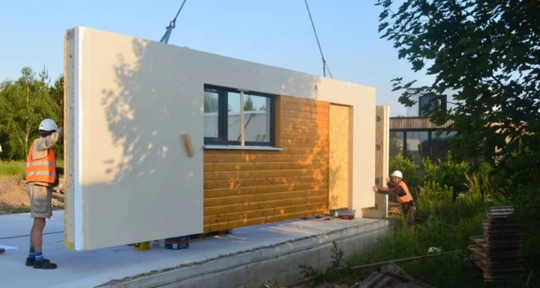 Montáž prefabrikované stěny pro dvoupodlažní dům s garáží.