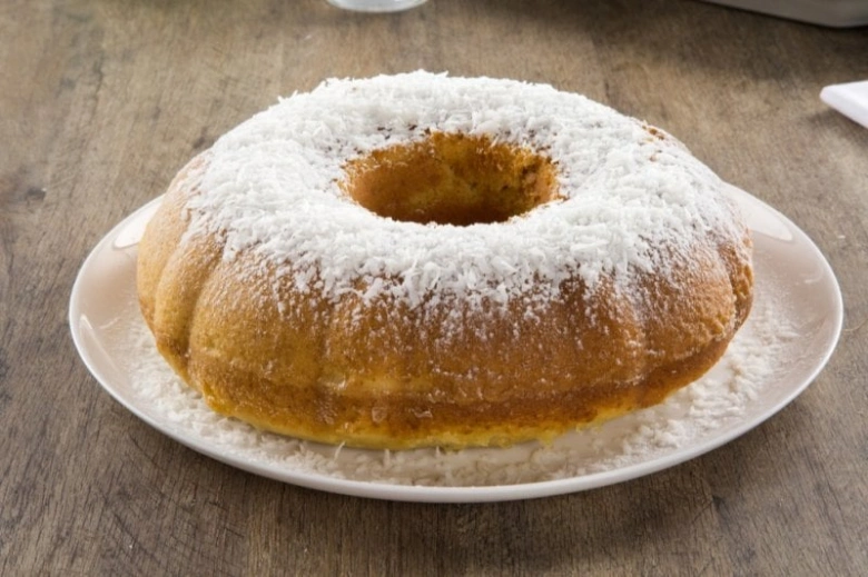 Slaná buchta posypaná moučkovým cukrem na bílém talíři.