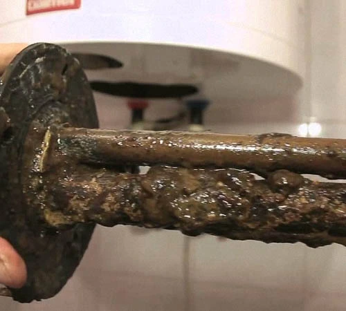 Zrezivělé součástky bojleru s usazeninami po vytažení z nádrže.