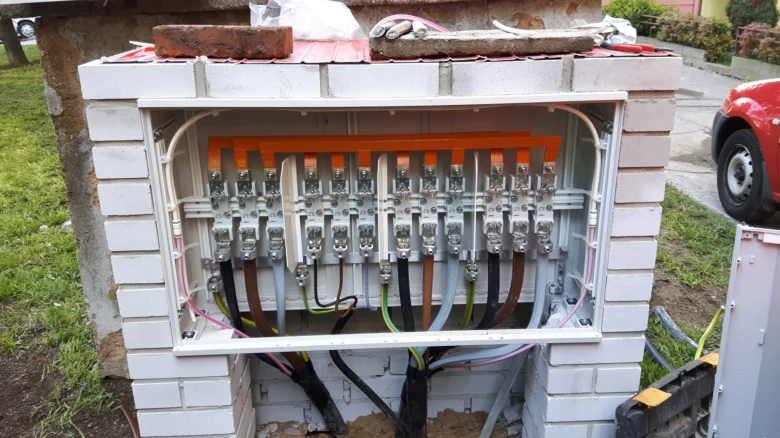 Otevřená elektrická skříň s barevně označenými kabely připojenými na svorkovnici.
