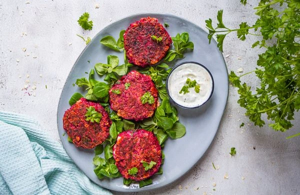 Veganí bramborové placky z řepy s dipem na listech.
